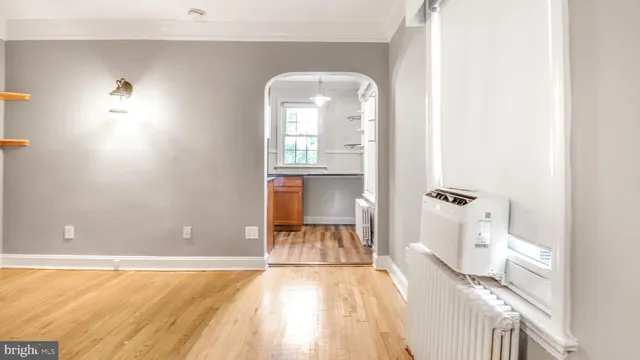 a view of a bedroom with a bed and wooden floor