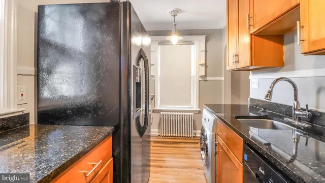 a kitchen with granite countertop a sink and a refrigerator