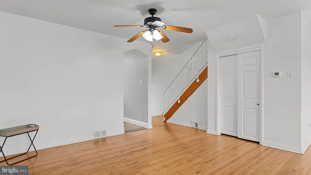 a very nice looking room with wooden floor ceiling fan