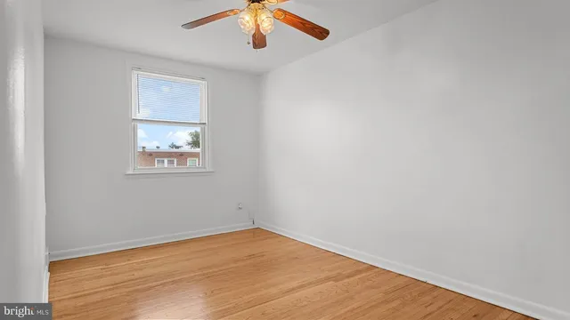 an empty room with a window and wooden floor
