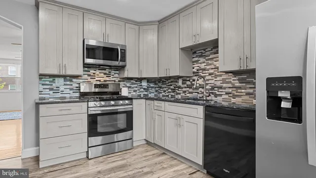 a kitchen with stainless steel appliances granite countertop a stove microwave and cabinets