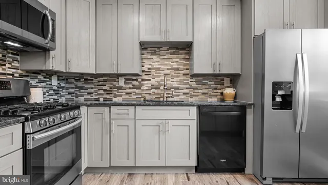 a kitchen with stainless steel appliances granite countertop a refrigerator stove and cabinets