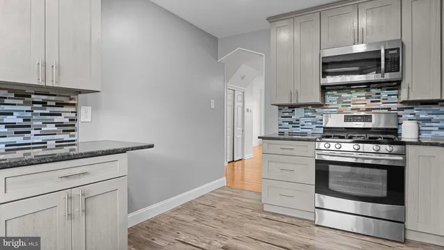 a kitchen with stainless steel appliances granite countertop a stove microwave and sink