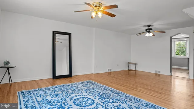 a view of an empty room with window and wooden floor