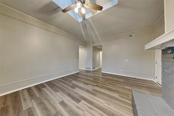 a view of an empty room with a chandelier fan