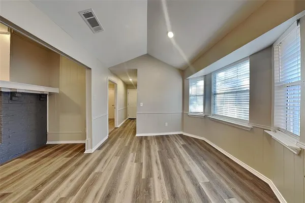 a view of a room with wooden floor and windows