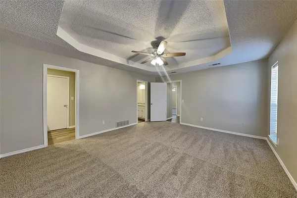 an empty room with fan and windows