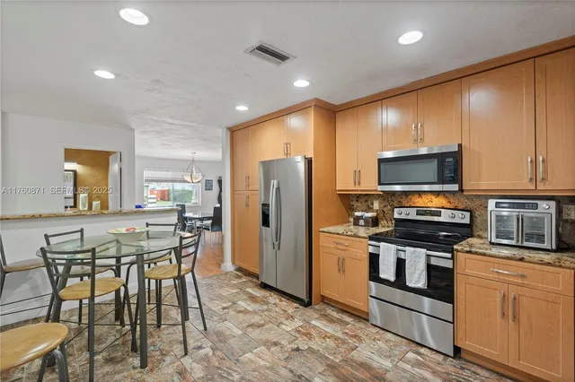 a kitchen with refrigerator and microwave