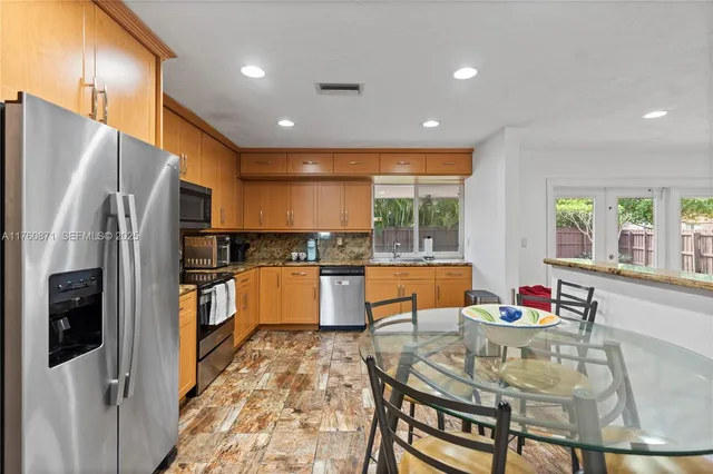 a kitchen with stainless steel appliances granite countertop a sink and a stove