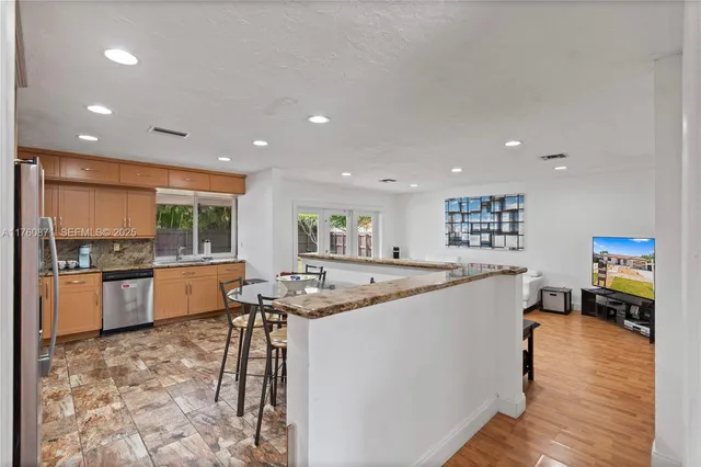 a living room with kitchen island furniture and a kitchen view
