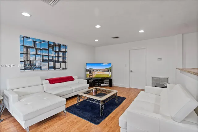 a living room with furniture and a wooden floor
