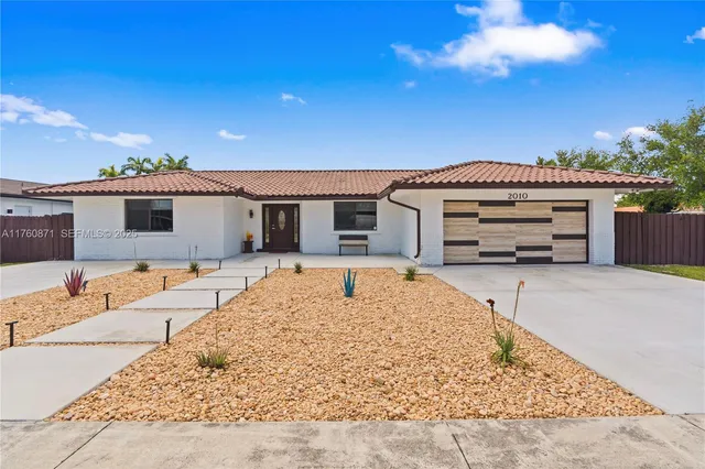 an aerial view of a house with swimming pool and outdoor seating