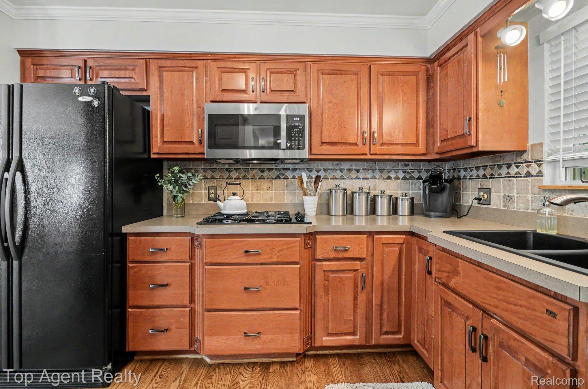 3759 Donley Avenue Rochester, MI 48309 - Photo 6 of 29 Kitchen featuring wood cabinetry, light-toned countertops, and a tiled backsplash