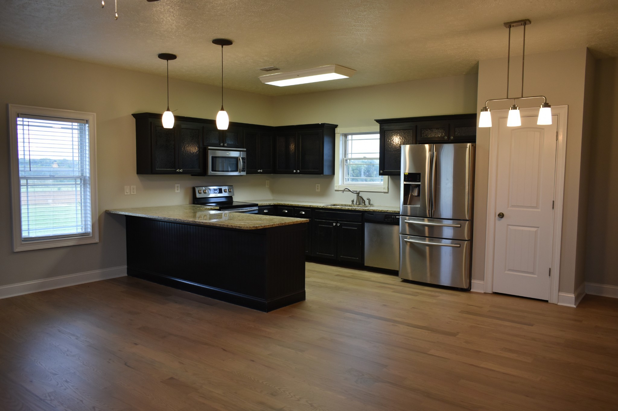 232 Sudberry Road Bell Buckle, TN 37020 - Photo 7 of 10 a kitchen with stainless steel appliances kitchen island granite countertop a refrigerator a sink dishwasher a stove and a refrigerator with wooden floor