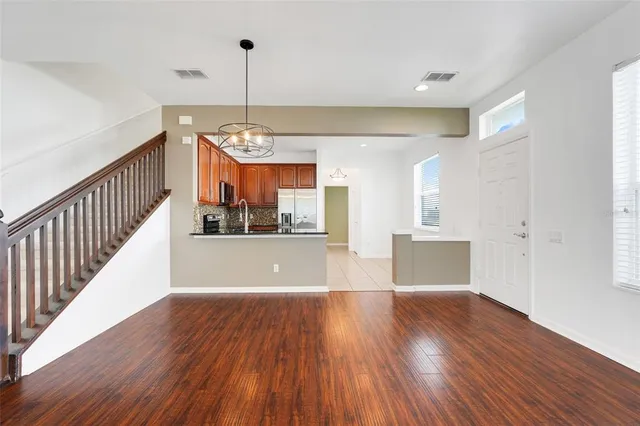 a view of a room with wooden floor and lots of windows