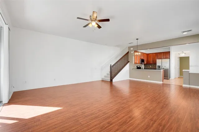 a view of a livingroom with a ceiling fan and wooden floor