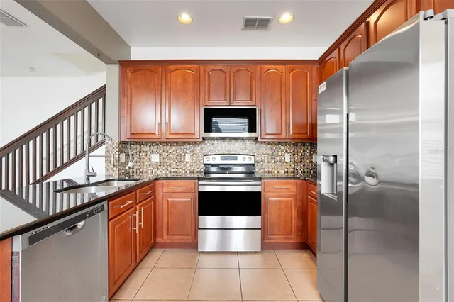 a kitchen with stainless steel appliances a stove a sink and a microwave