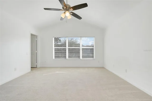 an empty room with chandelier fan