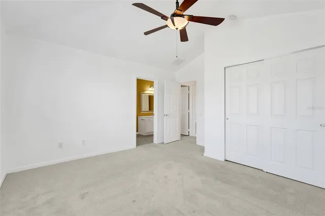 an empty room with a ceiling fan and closet