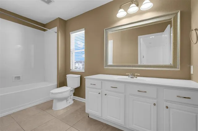 a bathroom with a toilet a sink a tub and a mirror