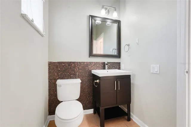 a bathroom with a toilet a sink and mirror