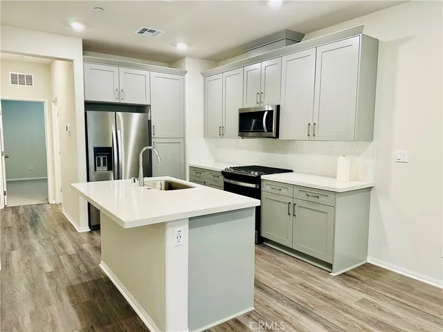 a kitchen with a sink a microwave a refrigerator and cabinets
