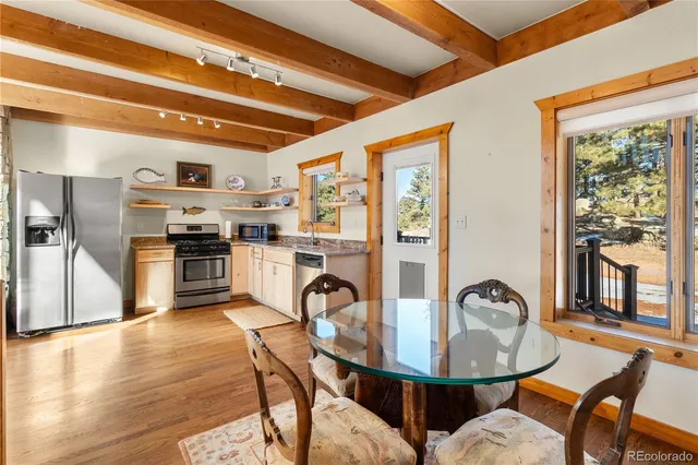 a dining hall with stainless steel appliances granite countertop a stove and a refrigerator