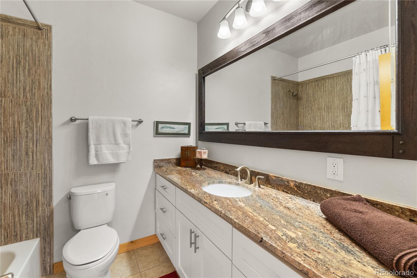 17245 Elbert Road Peyton, CO 80831 - Photo 31 of 45 a bathroom with a granite countertop sink mirror vanity and toilet