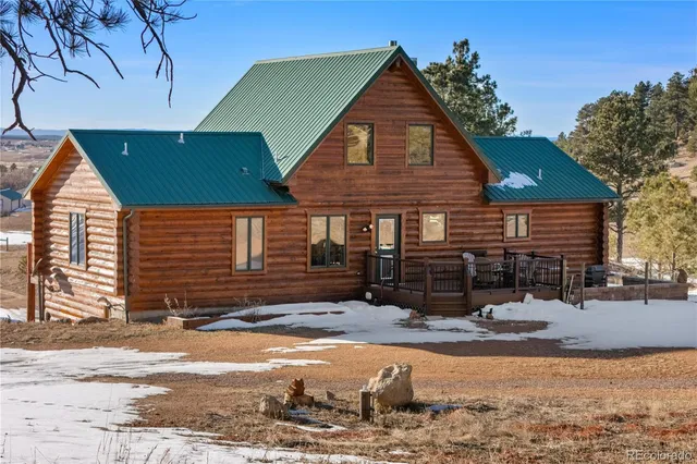 a view of a house with a wooden bench in a patio