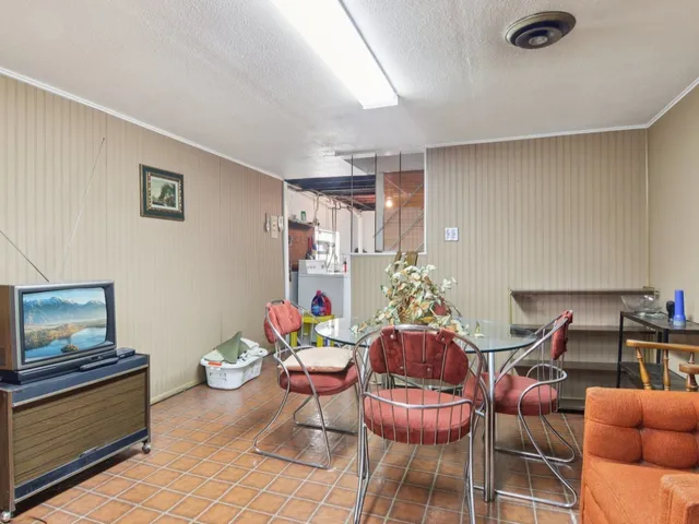 a living room with furniture a rug kitchen view and a large window