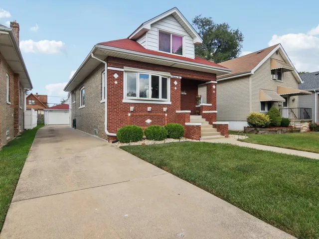 a front view of a house with a yard and trees