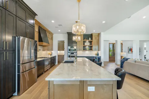 a kitchen with stainless steel appliances granite countertop a sink and a refrigerator