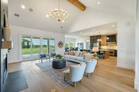 a living room with furniture a chandelier and a large window