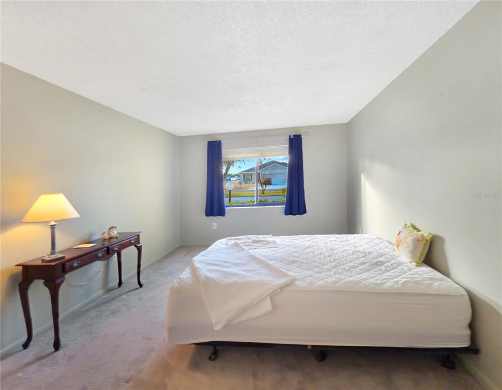 504 Silver Drive, Unit A Ocala, FL 34472 - Photo 14 of 28 a bedroom with a bed and a lamp on table