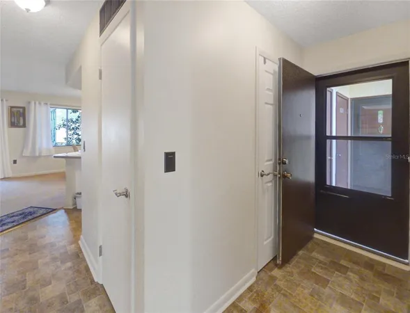 a view of a hallway with wooden floor and closet