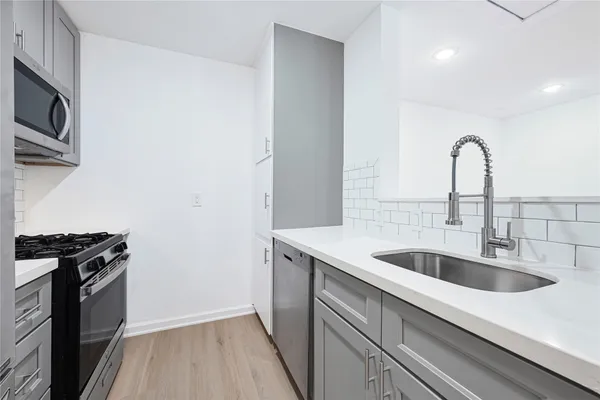 a kitchen with a sink and a stove top oven