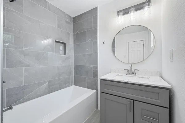 a bathroom with a sink a bathtub and a mirror