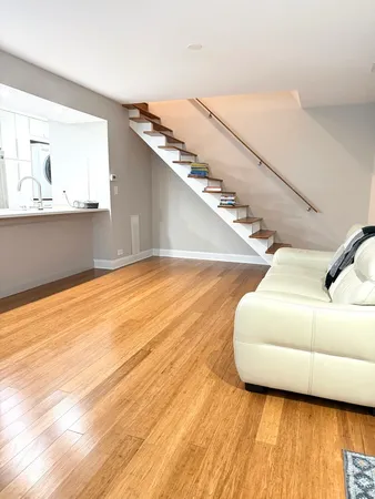 a view of a livingroom with wooden floor and stairs