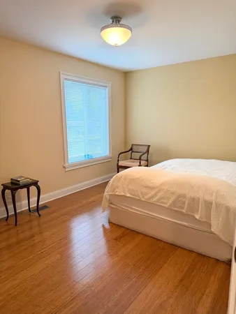 a large white bed in a room next to a window