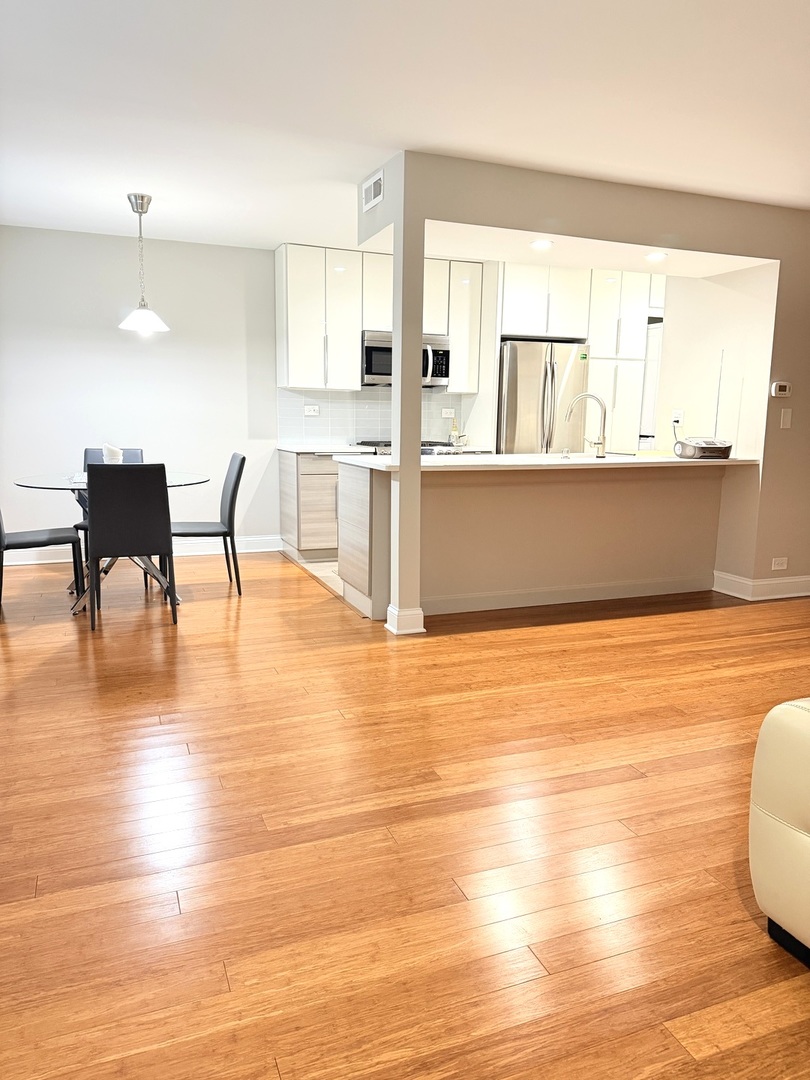 618 East Old Willow Road, Unit 183B Prospect Heights, IL 60070 - Photo 3 of 20 a view of a kitchen with kitchen island and a wooden floor