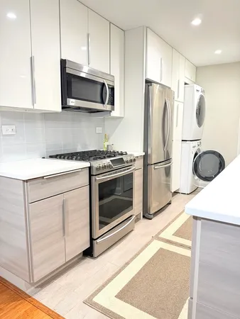 a kitchen with stainless steel appliances granite countertop a stove a refrigerator and a microwave