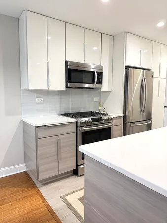 a kitchen with a refrigerator and a stove top oven