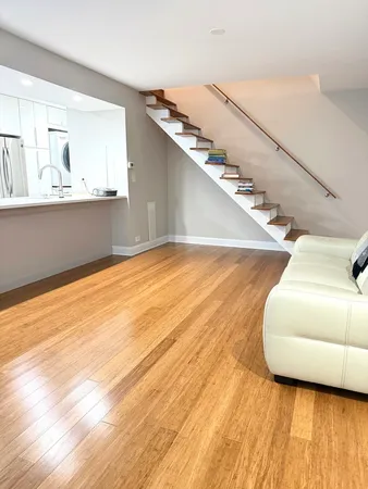 a view of a living room with furniture and wooden floor