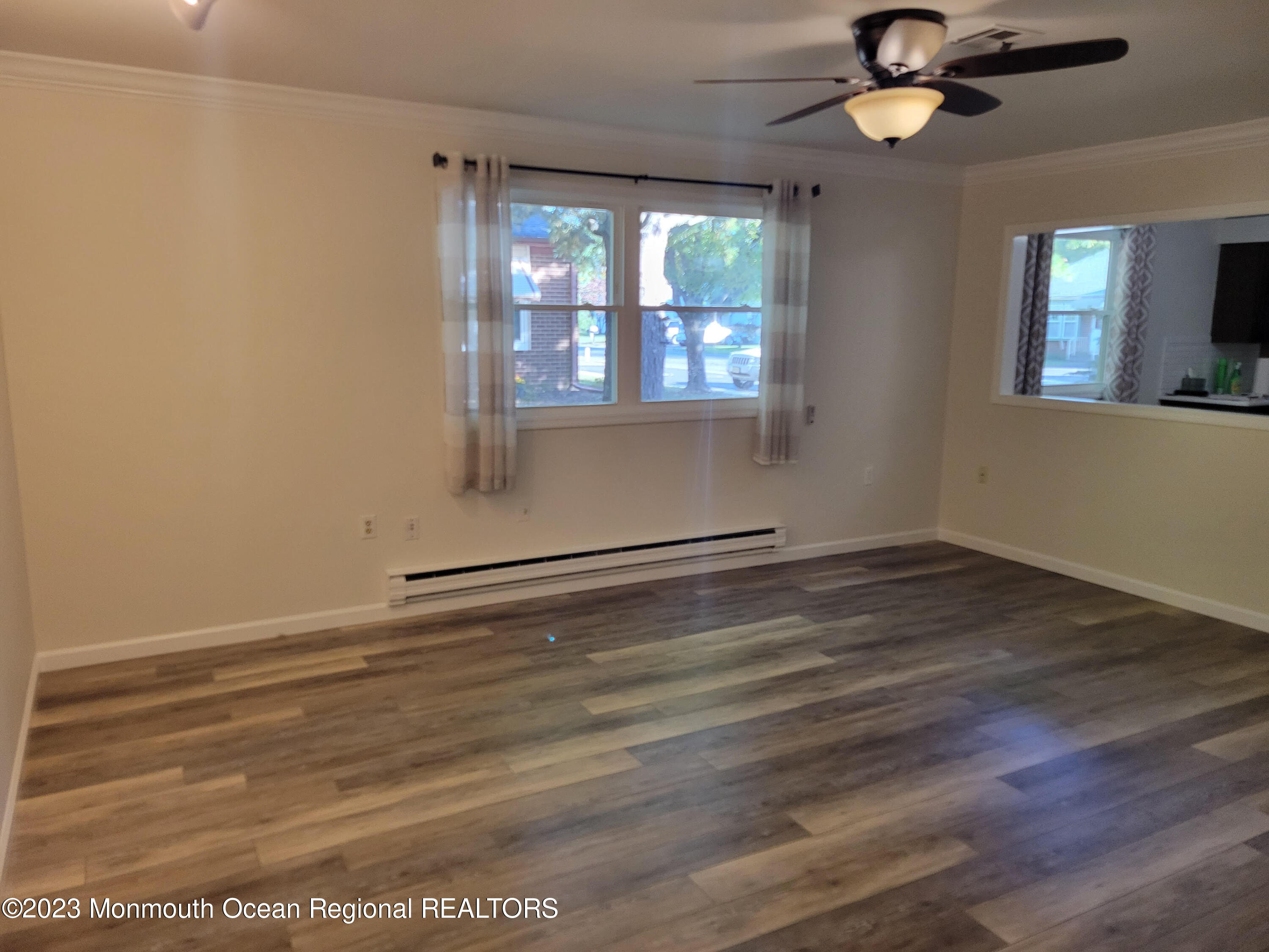 153 B Sunset Road, Unit 60 Manchester Township, NJ 08759 - Photo 7 of 15 an empty room with wooden floor fan and windows