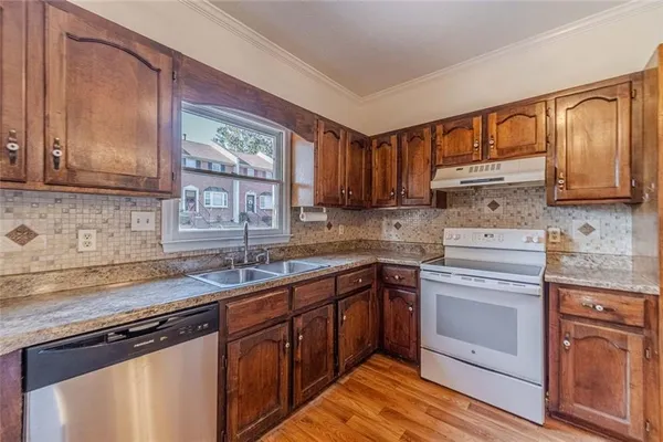 a kitchen with stainless steel appliances granite countertop a refrigerator and a stove top oven