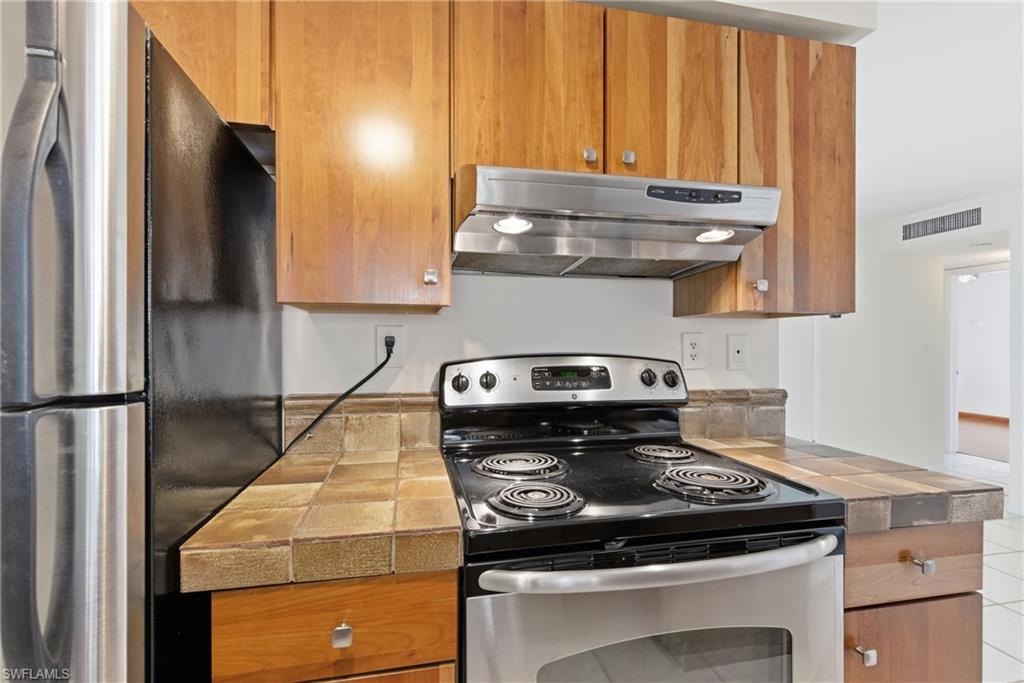 1235 Rordon Avenue Naples, FL 34103 - Photo 11 of 50 a kitchen with a stove and a refrigerator