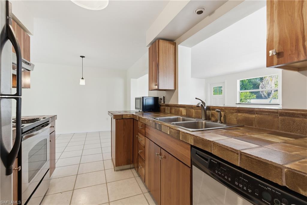 1235 Rordon Avenue Naples, FL 34103 - Photo 13 of 50 a kitchen with a sink stove and cabinets