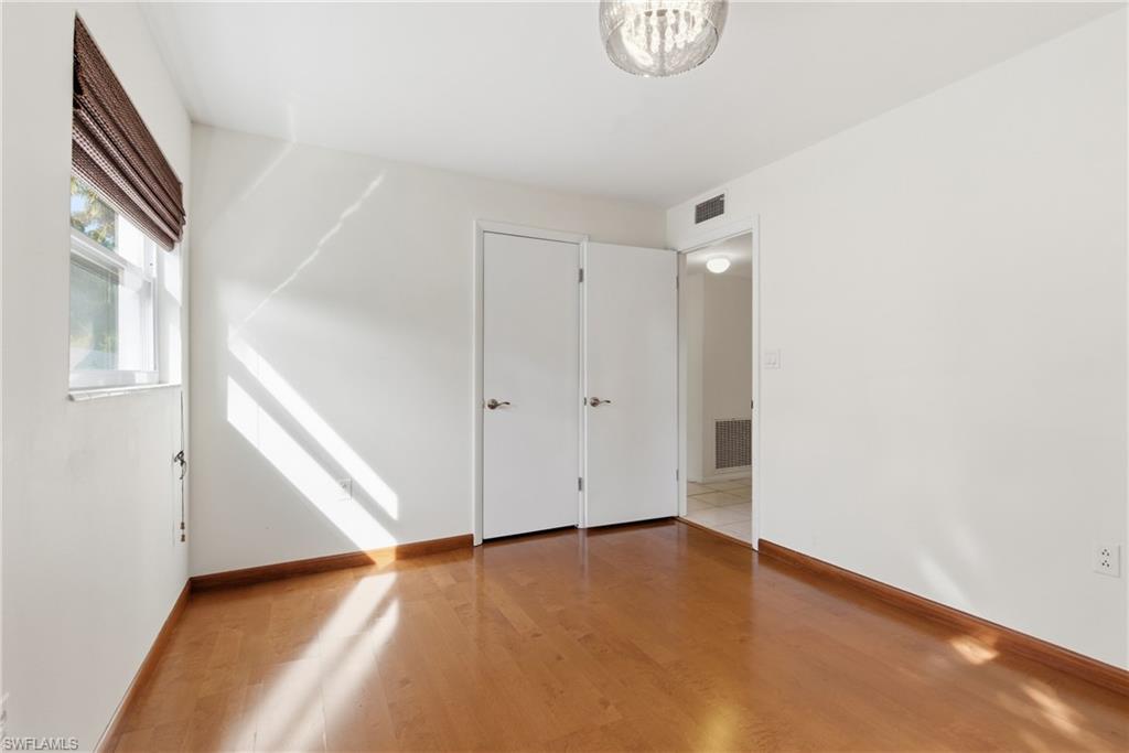 1235 Rordon Avenue Naples, FL 34103 - Photo 26 of 50 a view of an empty room with wooden floor and a window