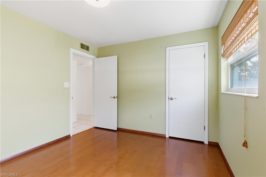 1235 Rordon Avenue Naples, FL 34103 - Photo 31 of 50 an empty room with wooden floor and windows
