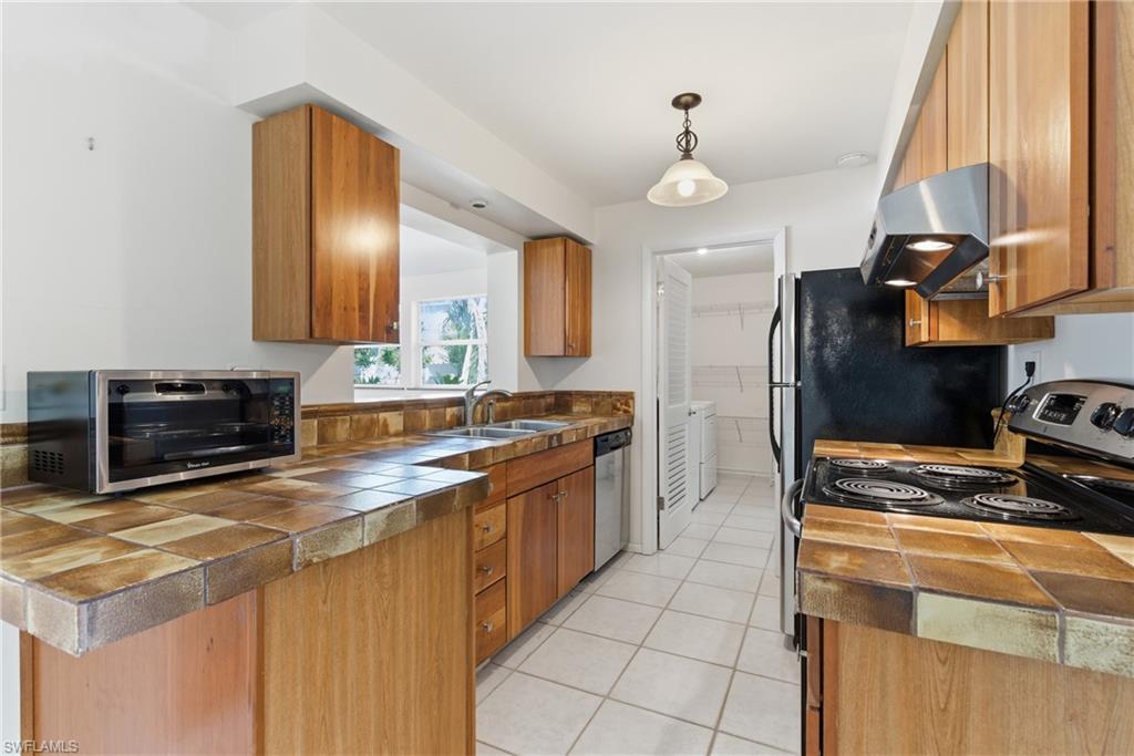 1235 Rordon Avenue Naples, FL 34103 - Photo 9 of 50 a kitchen with stainless steel appliances a stove sink and cabinets